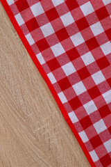Fototapeta na wymiar Checkered picnic cloth on wooden table, top view. Space for text