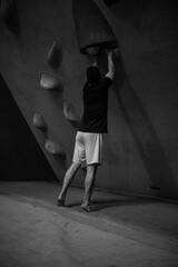 Climber in action on a climbing wall and boulder in Paris at Saint-Ouen