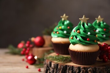 Christmas tree shaped cupcakes on wooden stand, closeup. Space for text