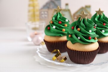 Christmas tree shaped cupcakes on white table. Space for text