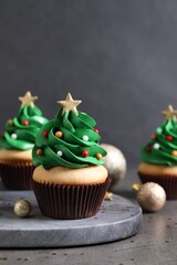 Christmas tree shaped cupcakes on grey table