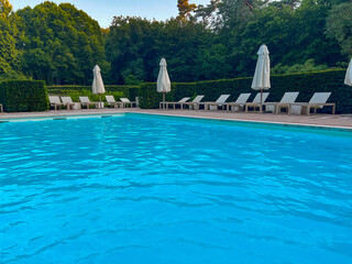Outdoor swimming pool in luxury hotel on sunny summer day. Time for relax