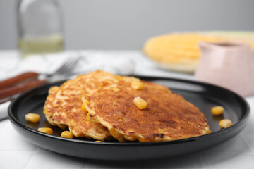 Tasty corn pancakes served on white table, closeup