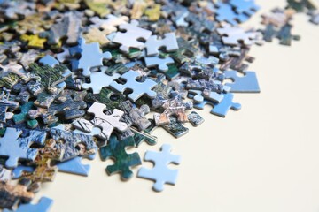Puzzle pieces on white table, closeup view
