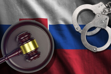 Slovakia flag with judge mallet and handcuffs in dark room. Concept of criminal and punishment,...