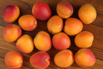 Ripe apricots on a brown wooden table. Top-down view. Closeup