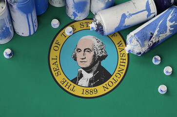 Washington US state flag and few used aerosol spray cans for graffiti painting. Street art culture...