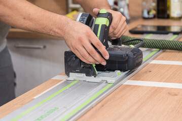 Schreiner mit Handkreissäge bei Holzbearbeitung