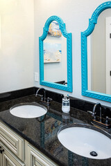 A cream and black granite jack and jill bathroom with double sinks