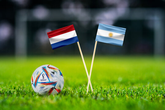QATAR, DOHA, DECEMBER 2. 2022: Netherlands - Argentina. Round of 8, Quater-finals. Official ball of Fifa world cup Qatar 2022 on green grass. Soccer stadium in background. Handmade national flags.