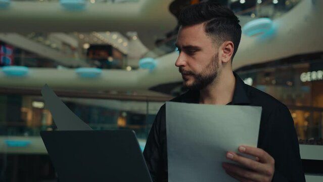 Male young businessman entrepreneur man doing corporate paperwork read business contract documentation paying bank loan bills online in banking app personal finances management processing information