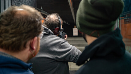 Trainer is teaching how to shoot in a shooting range USA