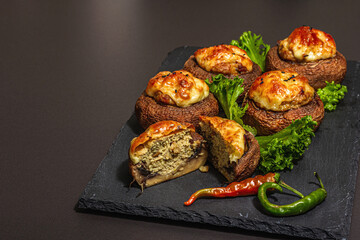 Baked stuffed mushroom caps ready for eating. Champignons, spices, vegetables, cheese