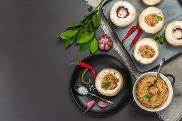 Raw stuffed mushroom caps ready for baking. Fresh champignons, spices, vegetables. Cooking process