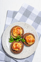 Baked stuffed mushroom caps ready for eating. Champignons, spices, vegetables, cheese