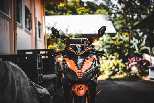 Ktm 390 duke motorcycle parked surrounded by a garden and a building