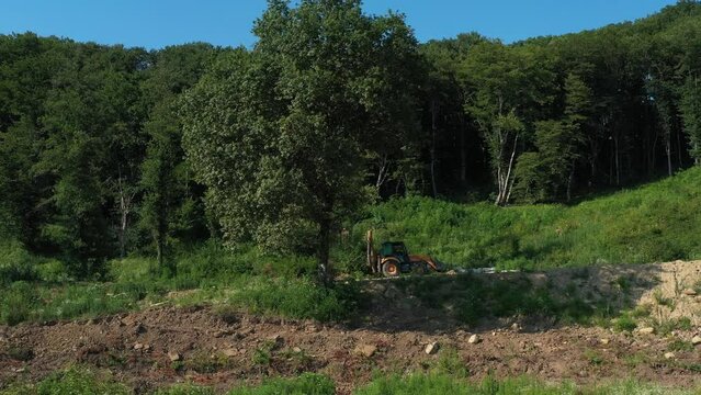 A modern tractor on a construction site from the air. A yellow wheel loader lifts and moves garbage. Heavy machinery is working at the facility.