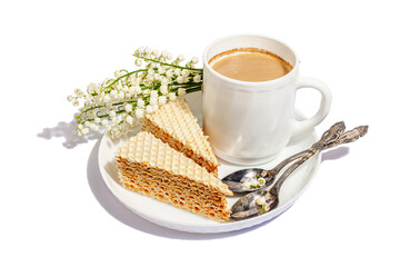 Cup of coffee and waffle cake isolated on a white background. Sweet dessert with lily valley bouquet
