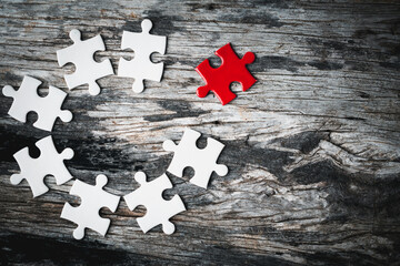 White details of jigsaw puzzle piece on wooden background. Concept of working together as a...
