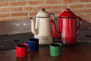 Coffee pot and cups enamelled in the wood stove on rural region of Brazil