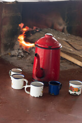 Coffee pot and cups enamelled in the wood stove on rural region of Brazil