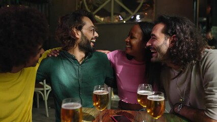 Happy multiracial young friends having fun together drinking beer at brewery bar - Millennial people celebrating toasting alcohol drinks at restaurant