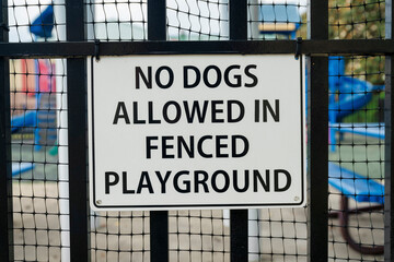 Close-up of a signage with No Dogs Allowed in Fenced Playground