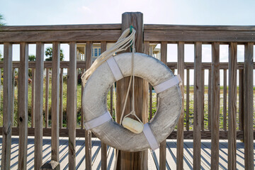 Destin, Florida- White lifebuoy hanging on a handrails of a boardwalk