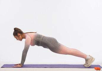 young woman doing fitness exercises on a white background isolated.sports exercises for body shaping