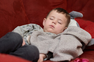 cute toddler sleeping on the couch after a meal