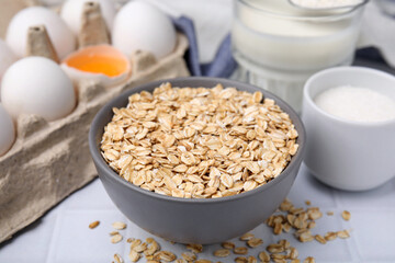 Different ingredients for cooking tasty oatmeal pancakes on white table, closeup