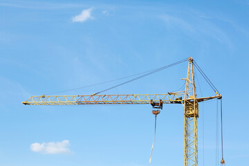 Modern tower crane against blue sky. Construction site