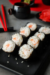 Tasty sushi rolls served on grey table, closeup