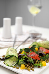 Plate of salad with mung beans on white table