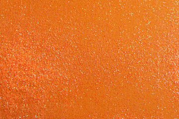 Shiny bright glitter on orange background, flat lay