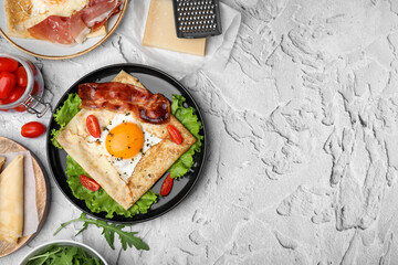 Delicious crepe with egg served on light gray textured table, flat lay with space for text. Breton galette - obrazy, fototapety, plakaty