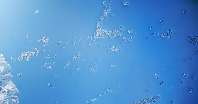Winter window frost time lapse of frozen crystals or frost pattern slowing forming on glass, winter background.