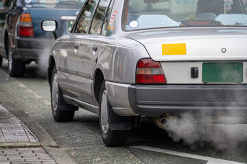 白い排気ガスを出して停車している車