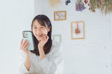 スマートフォンを見て笑う若い女性