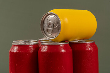 Cold red soda cans with a yellow one for conceptual use