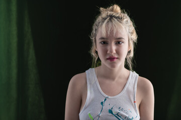 Young LA citizen in designer tank top and short plaid skirt poses in studio in a casual way.