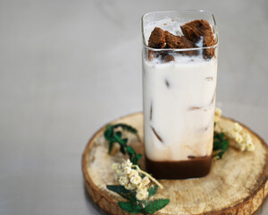 Iced coffee with caramel syrup in glass on coasters