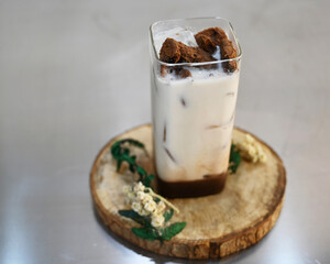 Iced latte coffee at home. Refreshing drink for summer. A glass of iced coffee latte with chocolate cookies