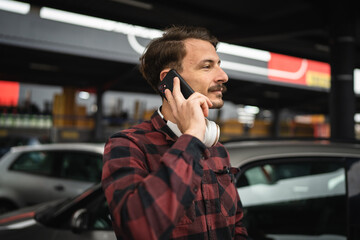 one man use mobile phone talk make a call at parking lot alone in day