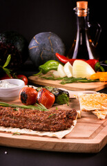 kebab spicy with vegetables in Turkish on the board