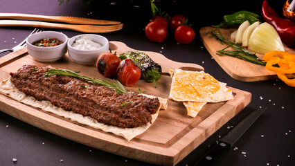kebab spicy with vegetables in Turkish on the board