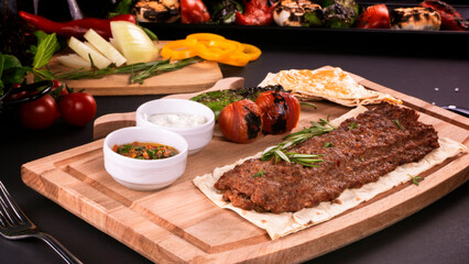 kebab spicy with vegetables in Turkish on the board