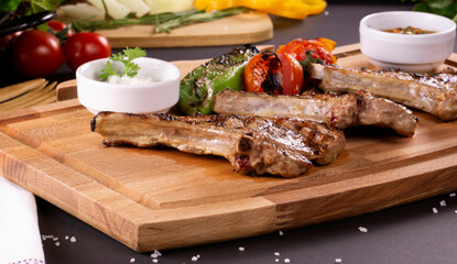 Pirzola Meat Kebabs Tomatoes and Onions and Grits on a board