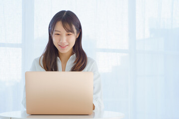 楽しそうにパソコンを操作する若い女性