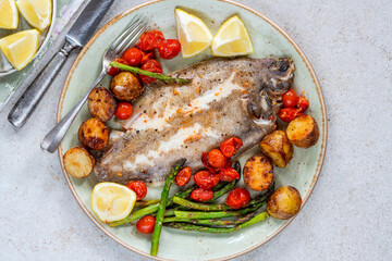 Lemon sole baked with potatoes, baby tomatoes and asparagus